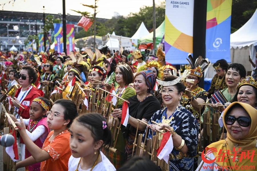2018年8月18日，雅加达亚运会在雅加达格拉罗蓬卡诺体育场盛大开幕。当天下午，在开幕式主场馆外，身穿印尼民族特色服饰的表演者与前来观看开幕式的观众一起载歌载舞，汇成一片欢乐的海洋。 金羊网特派雅加达记者 周巍 摄影报道